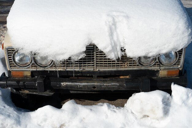 El automóvil en el estacionamiento está completamente cubierto de nieve Problemas después de fuertes nevadas Grandes ventisqueros en el estacionamiento y en las carreteras