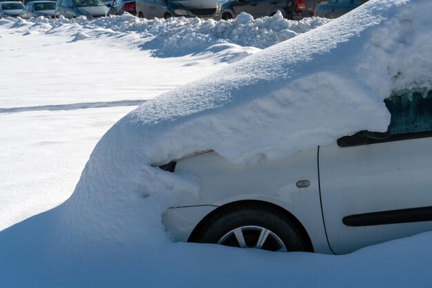 El automóvil en el estacionamiento está completamente cubierto de nieve Problemas después de fuertes nevadas Grandes ventisqueros en el estacionamiento y en las carreteras