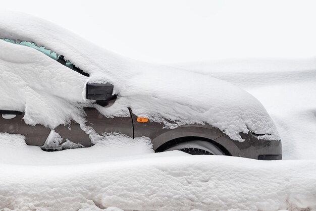 El automóvil de pasajeros está lleno de nieve en invierno