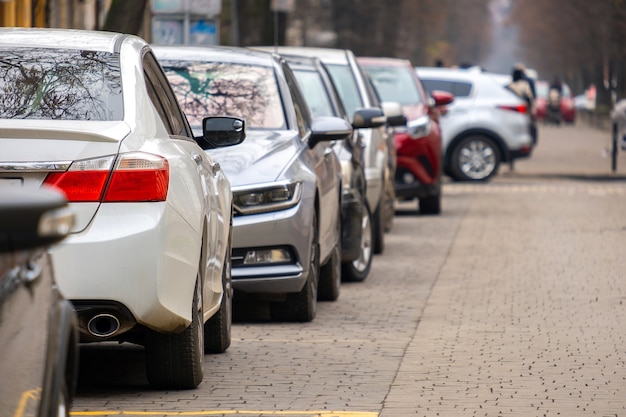 Automóviles estacionados en fila al lado de una calle de la ciudad.