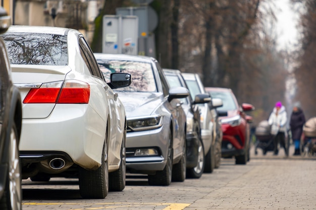 Foto automóviles estacionados en una fila al lado de la calle de la ciudad.