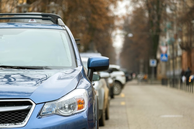 Los automóviles estacionados en una fila al lado de una calle de la ciudad.