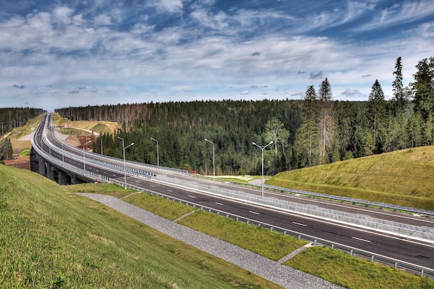 Foto autopista en la región de leningrado, nueva autopista priozersk, zanjas de drenaje de aguas pluviales antes del puente sobre el río smorodinka.