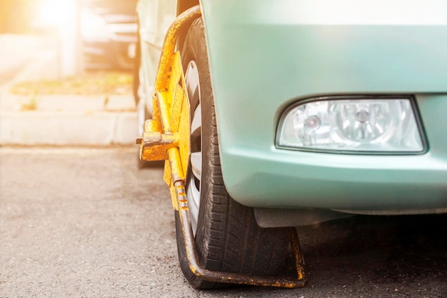 Autorad durch Radsperre wegen illegaler Parkverletzung blockiert. Festgeklemmtes Rad falsch geparkt