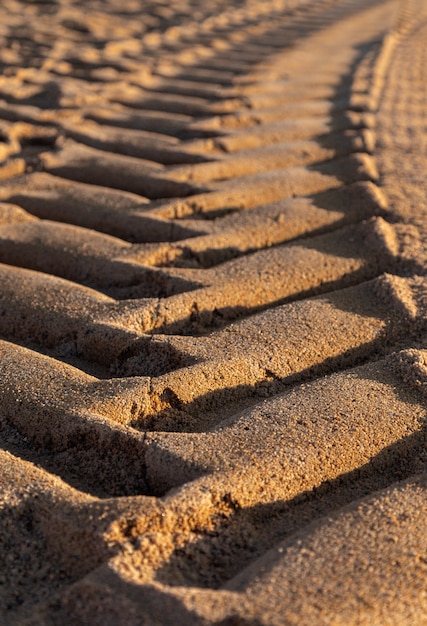 Autoreifendrucke auf Sand tagsüber, selektiver Fokus.