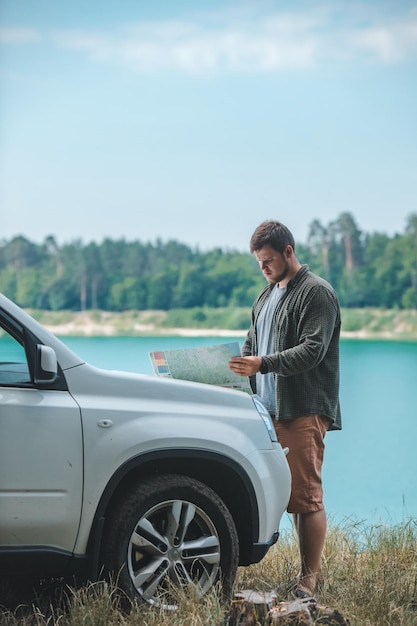 Autoreisekonzept Mann, der den Mann am SUV-Motorhaubensee im Hintergrund ansieht