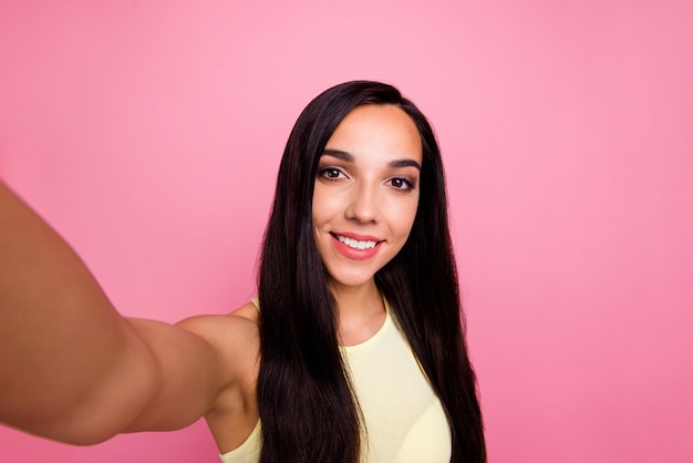 Foto autorretrato de niña aislada sobre pared rosa pastel