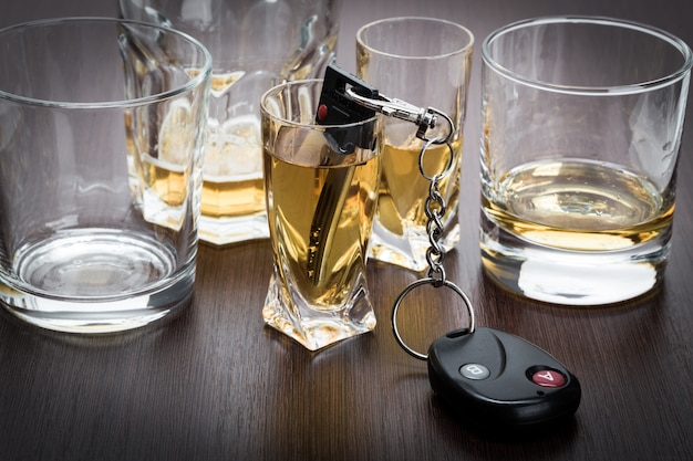 Autoschlüssel auf der Bar mit verschüttetem Alkohol