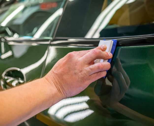 Foto autoservice-mitarbeiter trägt nanobeschichtung auf ein auto auf, nahaufnahme