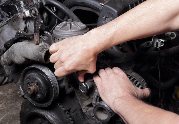 Autoservice Motorreparaturmechanikerhände mit Schraubenschlüssel-Generatormutter