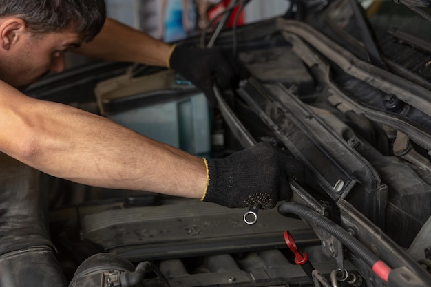 Autoservice-Reparaturwartung und Personenkonzept Automechaniker, der nach einer Fehlfunktion im Automotor sucht