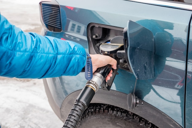 Autoservicio de boquilla de reabastecimiento manual en el tanque de combustible en la estación de combustible