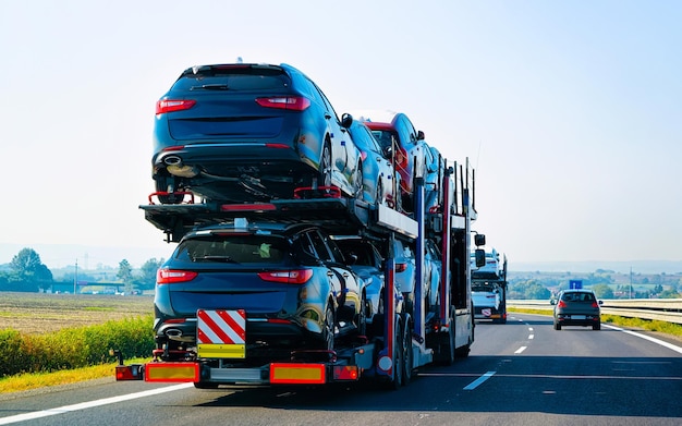 Autotransporter auf der Straße oder Autobahn Polens. LKW-Transporter bei Logistikarbeiten. Anhänger mit Cargocar-Antrieb. Lieferung für die Transport-Exportindustrie. Schwerlaster. Fahrzeug befördern. Autotransport.