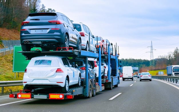 Autotransporter-Transporter auf der Straße. Autotransporter auf der Auffahrt. Europäische Transportlogistik im Speditionsbetrieb. Schwerlastanhänger mit Fahrer auf der Autobahn.