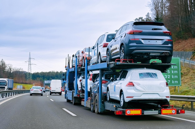 Autotransporter-Transporter auf der Straße. Autotransporter auf der Auffahrt. Europäische Transportlogistik im Speditionsbetrieb. Schwerlastanhänger mit Fahrer auf der Autobahn.