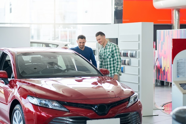 Autoverkäufer zeigt Kundenauto im Autohaus.