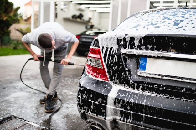 Autowäsche mit Druckwasser, Autodetailing (oder Valeting) Konzept.