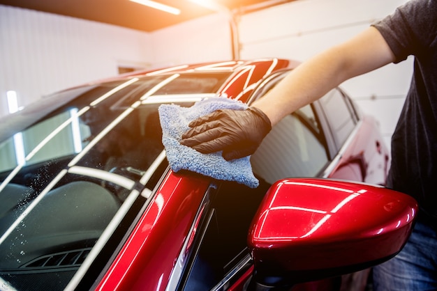 Autowerkstatt poliert Auto mit Mikrofasertuch.