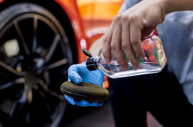 Autowerkstatt poliert Autoräder mit Mikrofasertuch.