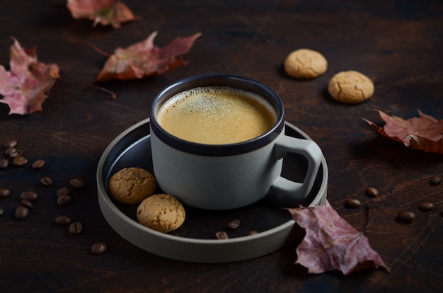 Autumn Composition mit Tasse Kaffee und Autumn Leaves auf dunklem Holztisch