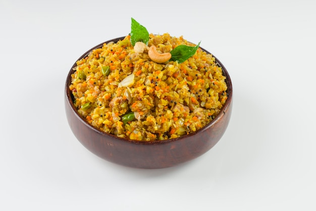 Aval upma ou poha upma ou kanda poha upma, item de café da manhã indiano saudável que é muito saboroso e fácil de cozinhar e é organizado em uma tigela de madeira com fundo texturizado branco.