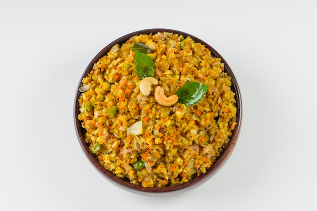 Aval upma ou poha upma ou kanda poha upma, item de café da manhã indiano saudável que é muito saboroso e fácil de cozinhar e é organizado em uma tigela de madeira com fundo texturizado branco.