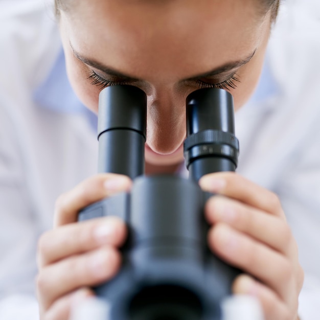 Avance de la ciencia médica Captura recortada de una joven científica usando un microscopio en un laboratorio