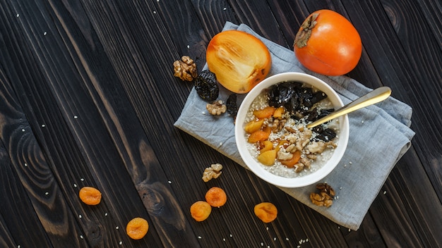 Aveia com caqui em uma mesa de madeira preta