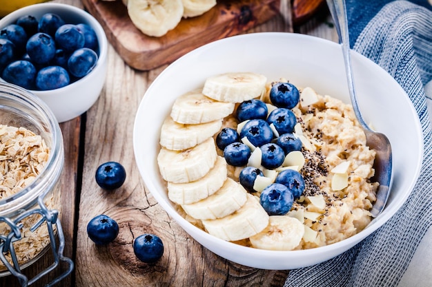 Aveia de pequeno-almoço com bananas mirtilos sementes de chia e amêndoas Foco seletivo