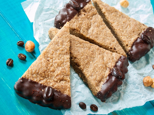 Avelã gourmet e barras de chocolate de café em papel pergaminho branco.