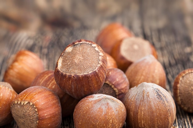 Avelãs inteiras em uma mesa de madeira, com casca