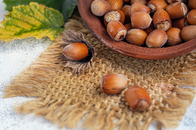 Avelãs sobre um fundo claro com folhas verdes. Contém vitaminas e minerais benéficos.