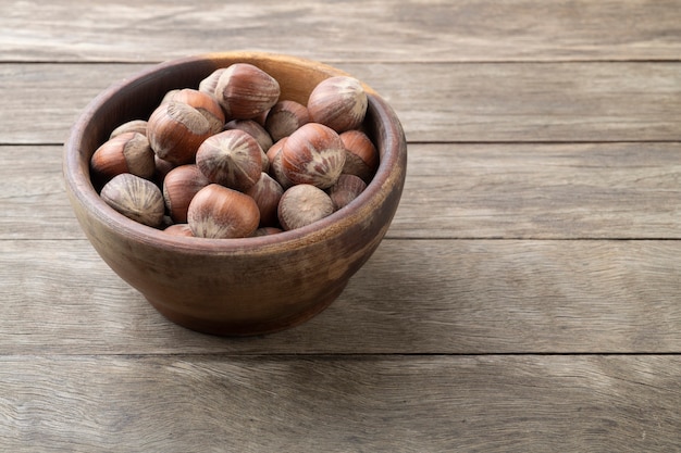 Avellanas en un recipiente sobre la mesa de madera