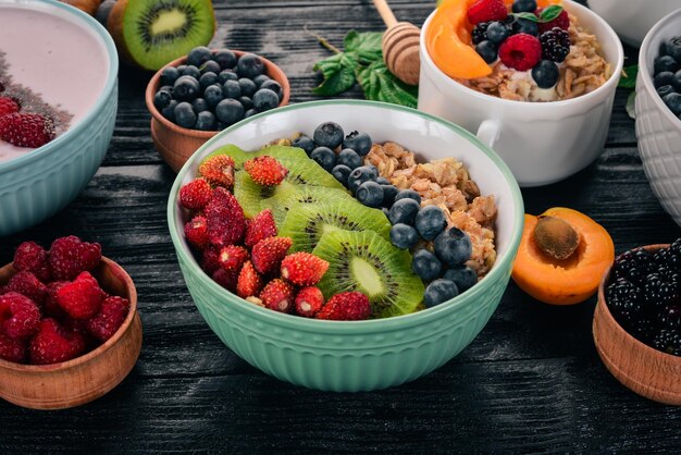 Avena con arándanos, fresas y kiwi Sobre un fondo de madera Vista superior Espacio libre para texto