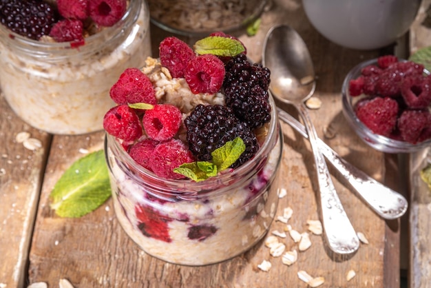 Avena casera saludable durante la noche Avena con bayas Gachas de avena en porciones con frambuesa fresca y mora en un frasco de vidrio Desayuno saludable de verano