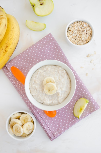 Avena cremosa con rodajas de plátano y manzana en un tazón