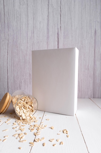 Avena en un frasco de vidrio sobre un fondo blanco de madera