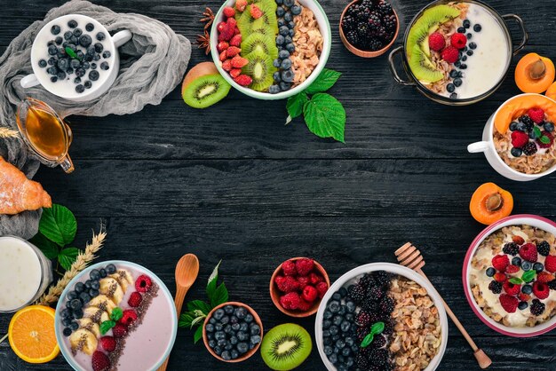 Avena con frutas de yogur y bayas en platos Desayuno Sobre un fondo de madera negra Vista superior Espacio libre para texto