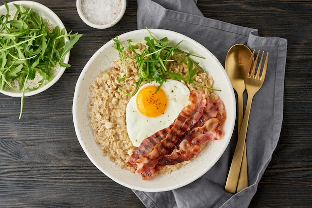 Avena, huevo frito y tocino frito. Balance de proteínas, grasas, carbohidratos. De cerca