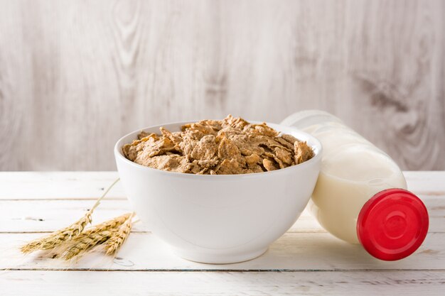 Avena leche y cereales en la mesa de madera blanca