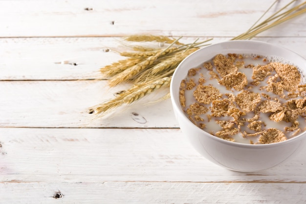 Avena leche y cereales en la mesa de madera blanca