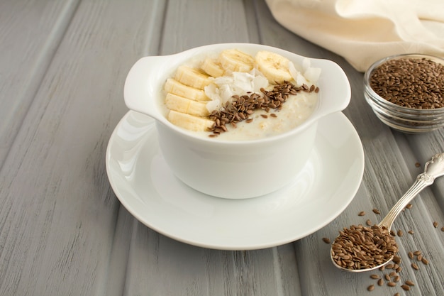 Avena con leche con semillas de lino, banana y chips de coco