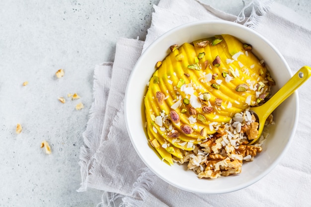 Avena con mango y nueces en un tazón blanco