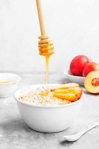 Avena con nectarina y miel sobre un fondo gris