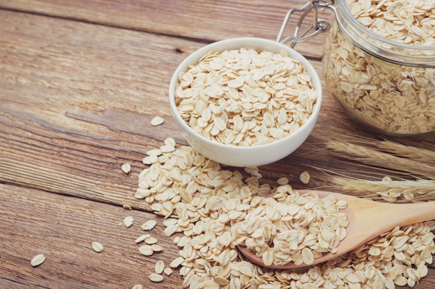 Avena o copos de avena en un recipiente en la mesa de madera. Tonificado.