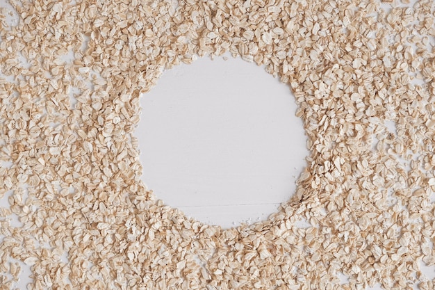 Avena seca esparcida en forma de círculo sobre un fondo blanco