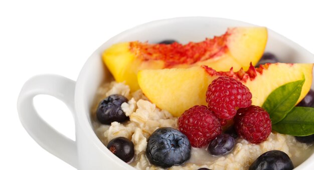 Avena en taza con bayas aislado en blanco