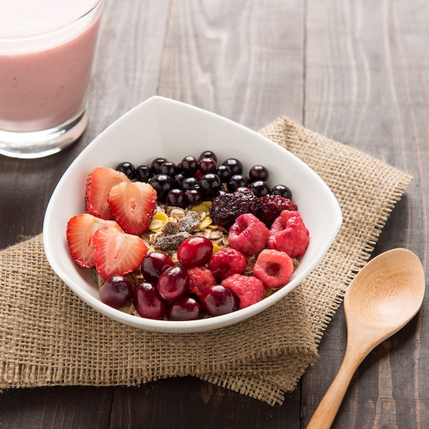 Avena en un tazón cubierto con arándanos frescos, arándanos, fresas, frambuesas, moras y batido de bayas.