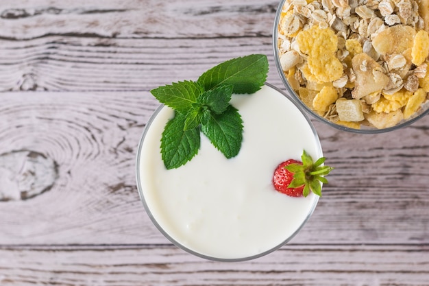 Foto avena y yogur con fresas y menta en una mesa de madera