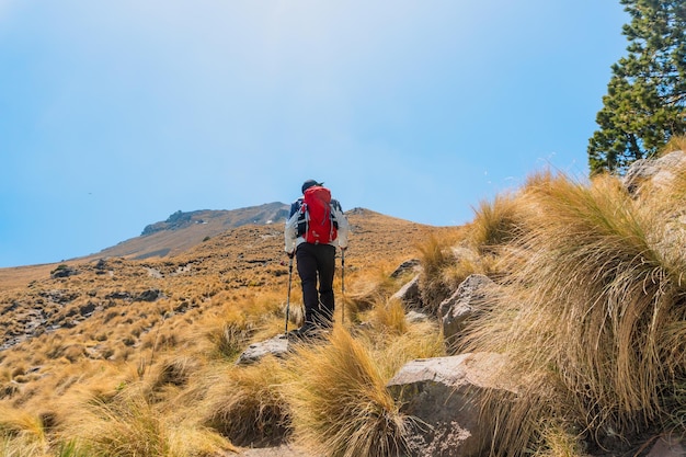 Aventura ao ar livre homem caminhando para o topo da montanha inspiração e realização pessoal